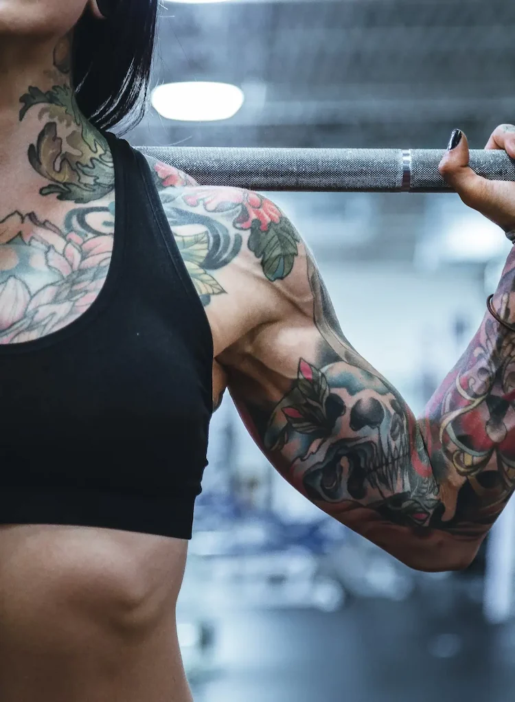 Tatooed woman lifing weights