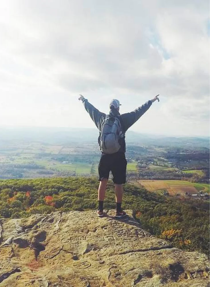 Man standing on top of a mountain looking at the view