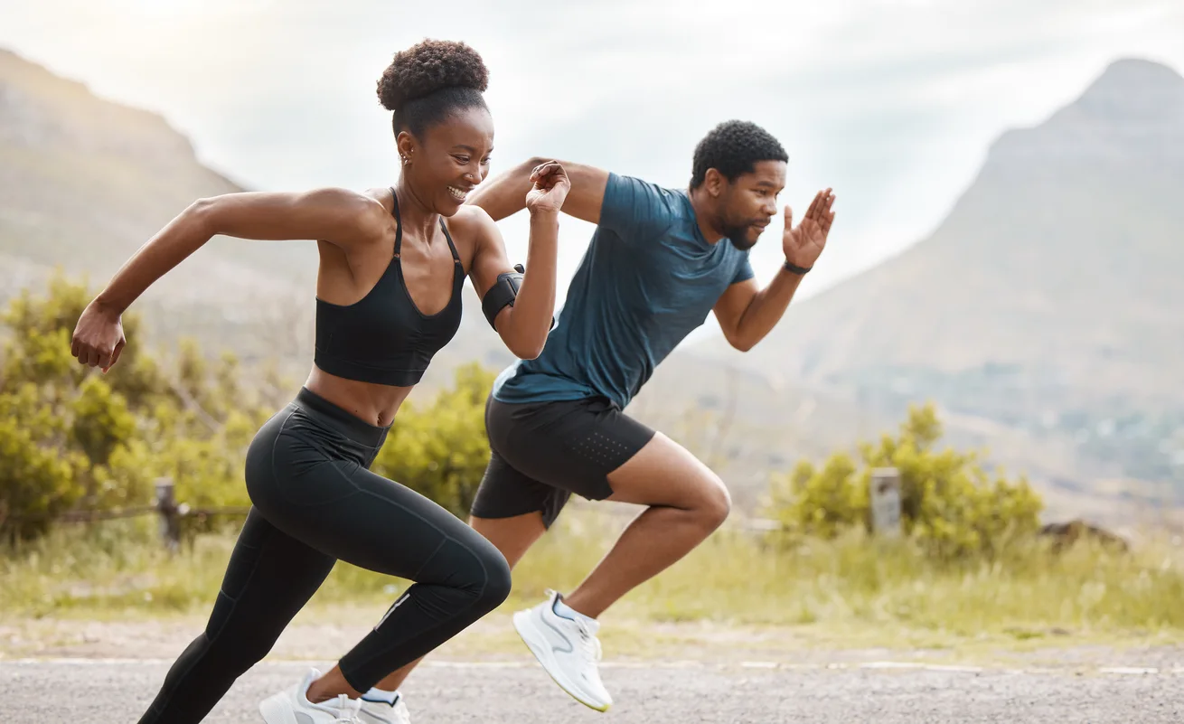 Two people racing each other with a mountain backdrop