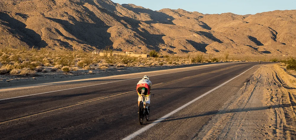 Jasmijn Muller cycling with a mountain view up ahead