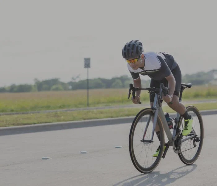 Man power cycling down a road