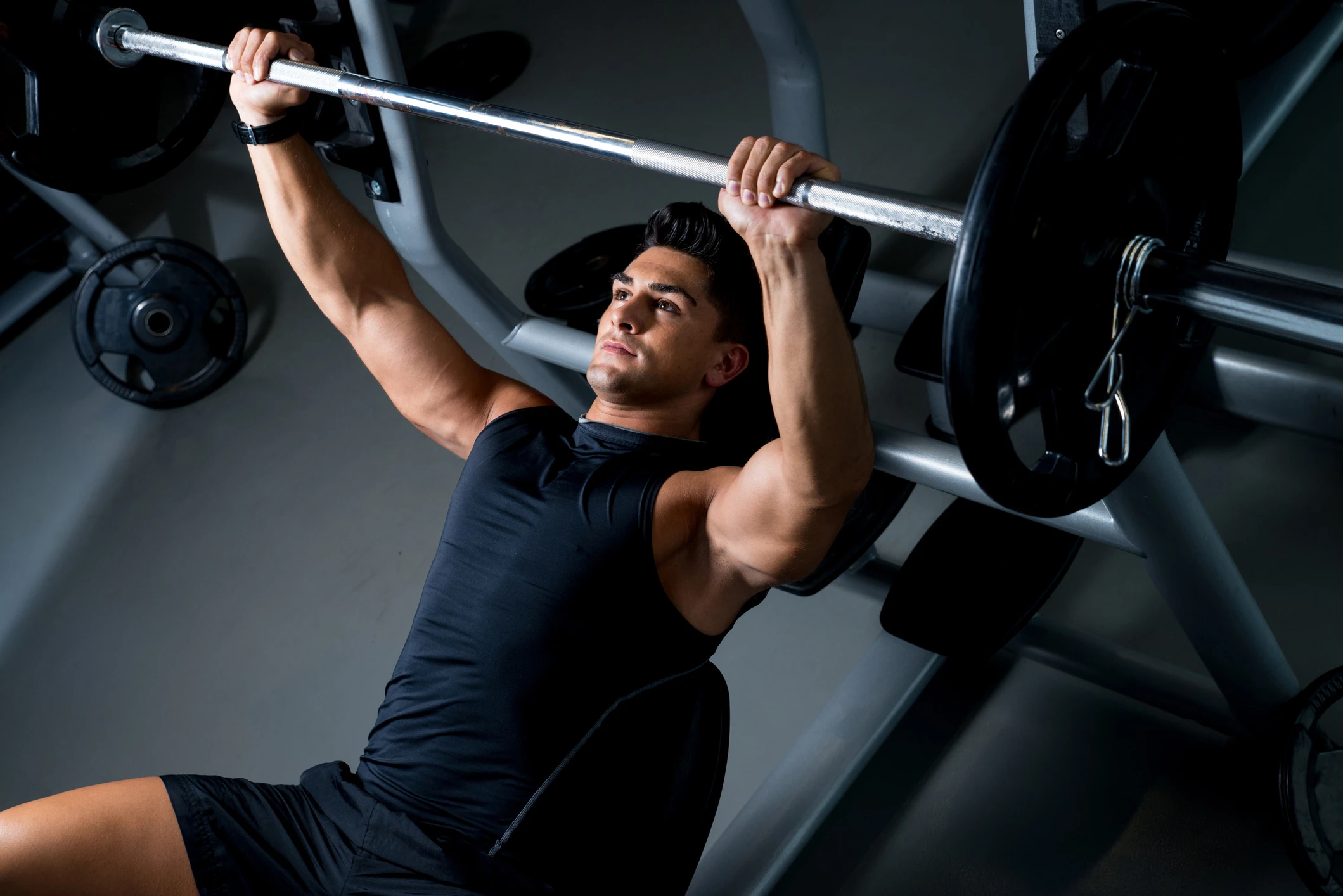 man at the gym doing bench press as part of a superset