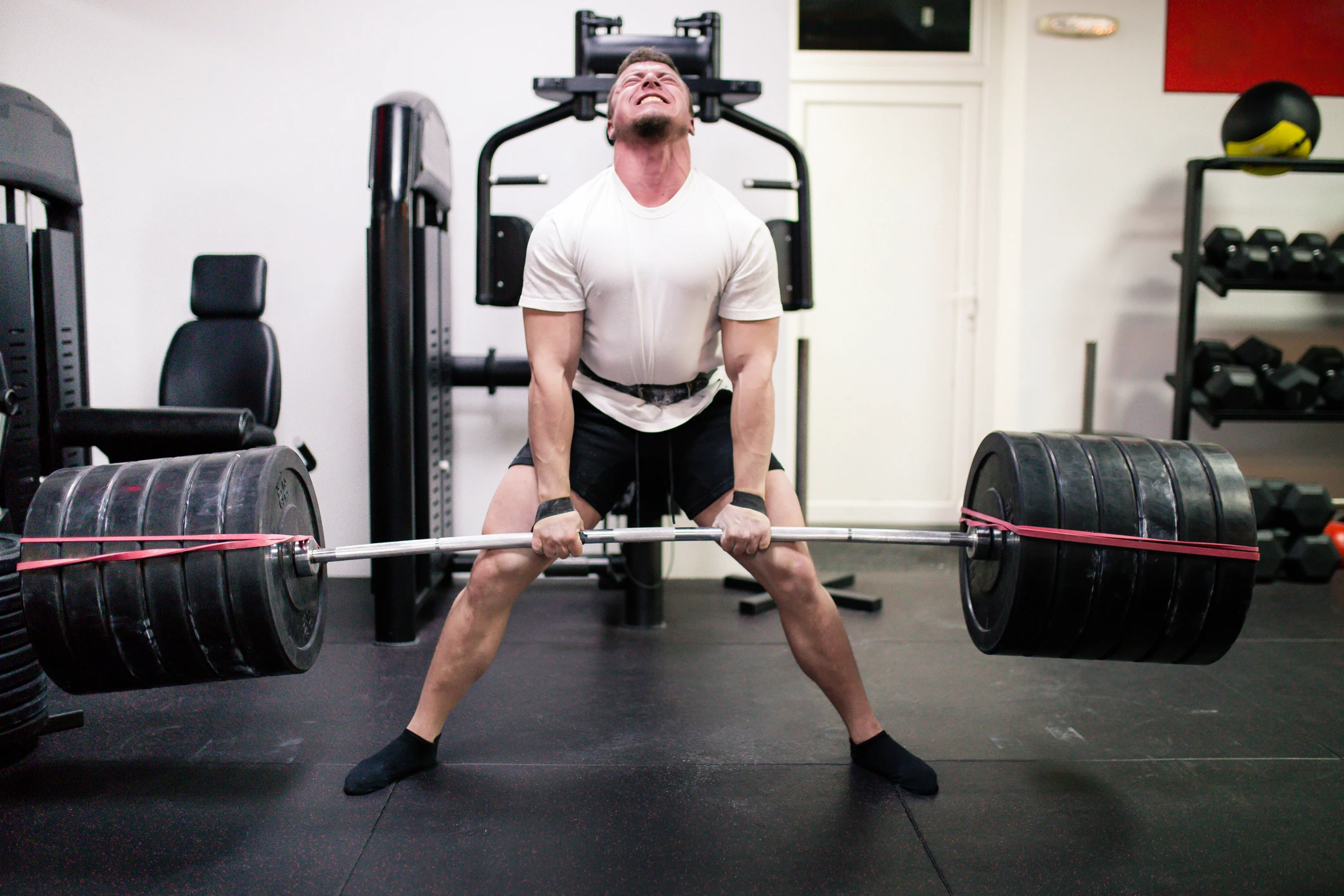 man in gym doing a deadlift with too much weight, ego lifting